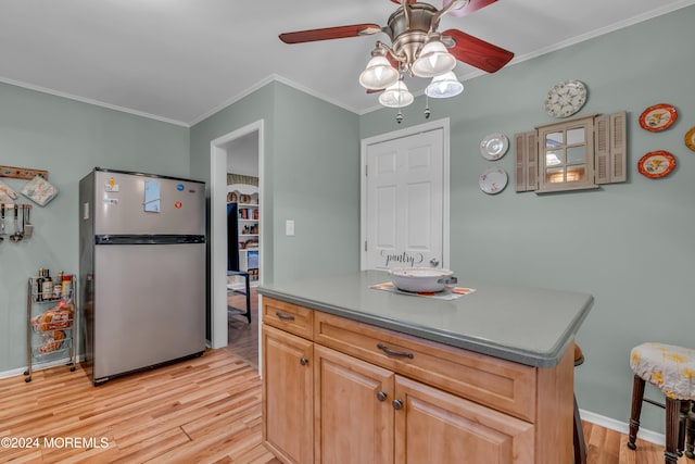 kitchen featuring light brown cabinetry, stainless steel fridge, light wood-type flooring, ceiling fan, and crown molding