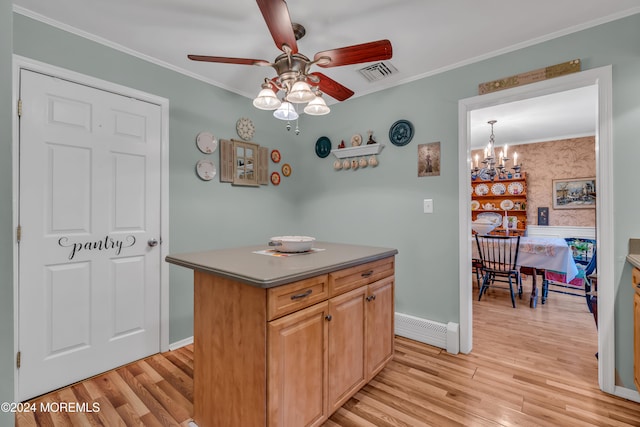 kitchen with crown molding, light hardwood / wood-style flooring, a kitchen island, and ceiling fan with notable chandelier