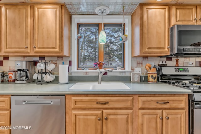 kitchen with decorative backsplash, sink, decorative light fixtures, and appliances with stainless steel finishes