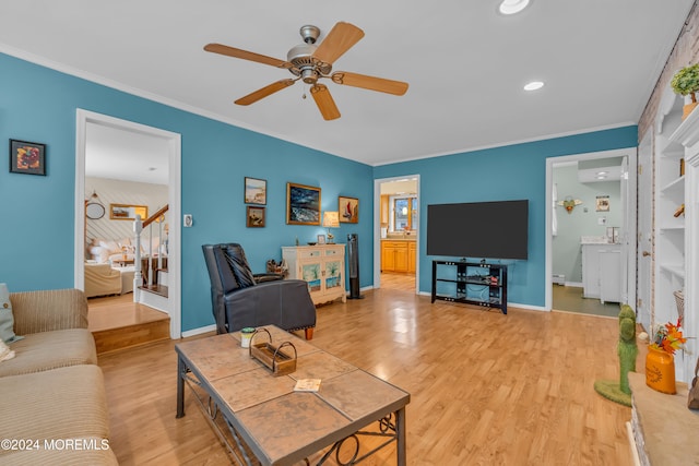 living room featuring ceiling fan, light wood-type flooring, crown molding, and a baseboard radiator