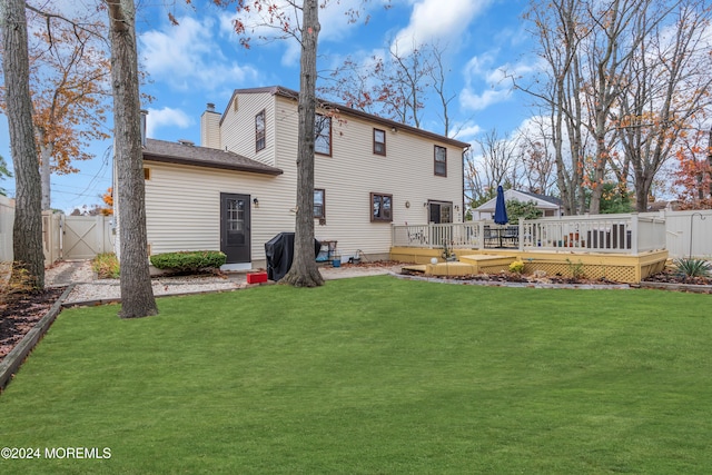 back of property with a lawn and a deck