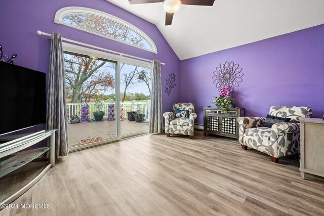 unfurnished room with hardwood / wood-style floors, vaulted ceiling, ceiling fan, and a baseboard heating unit