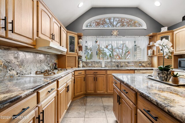 kitchen with light stone countertops, sink, vaulted ceiling, and stainless steel gas cooktop