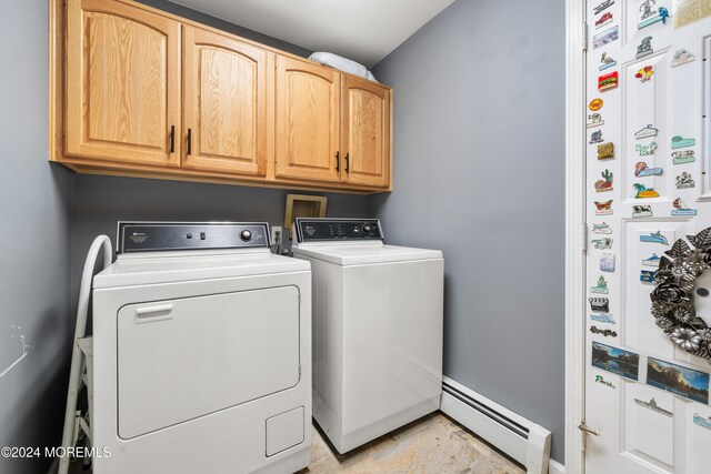 washroom featuring cabinets, separate washer and dryer, and a baseboard heating unit