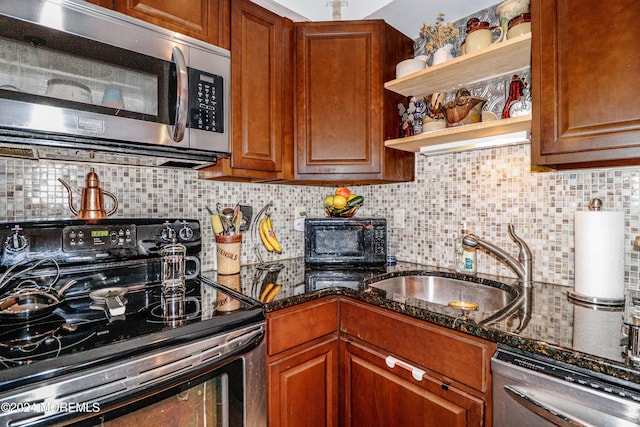 kitchen featuring decorative backsplash, dark stone countertops, sink, and appliances with stainless steel finishes