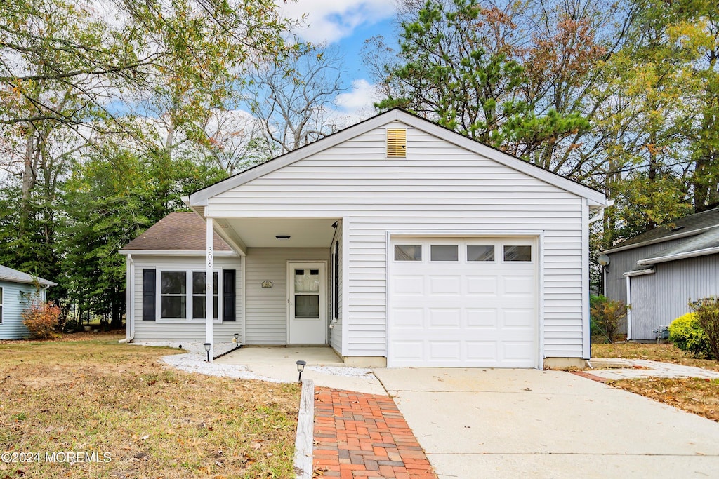 view of front of home with a front yard and a garage