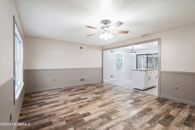 unfurnished room with ceiling fan and wood-type flooring