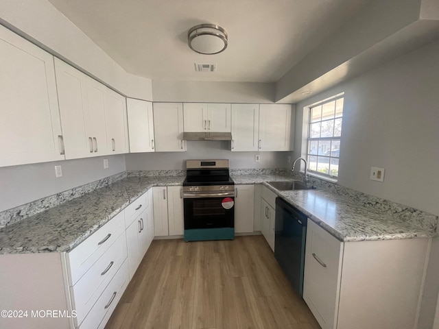 kitchen with dishwasher, sink, light wood-type flooring, stainless steel range, and white cabinetry