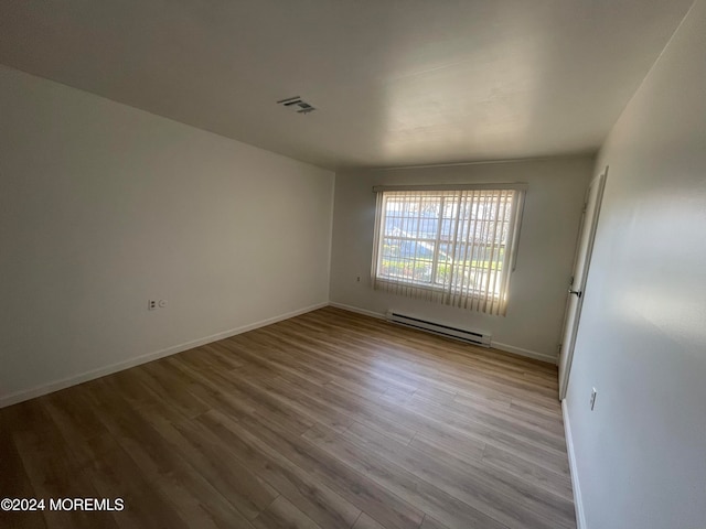 spare room featuring light hardwood / wood-style flooring and a baseboard radiator