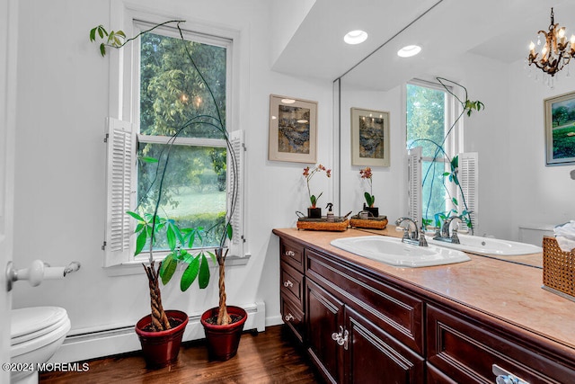 bathroom featuring toilet, a healthy amount of sunlight, a notable chandelier, and hardwood / wood-style floors