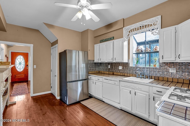 kitchen featuring white appliances, white cabinets, decorative backsplash, sink, and ceiling fan