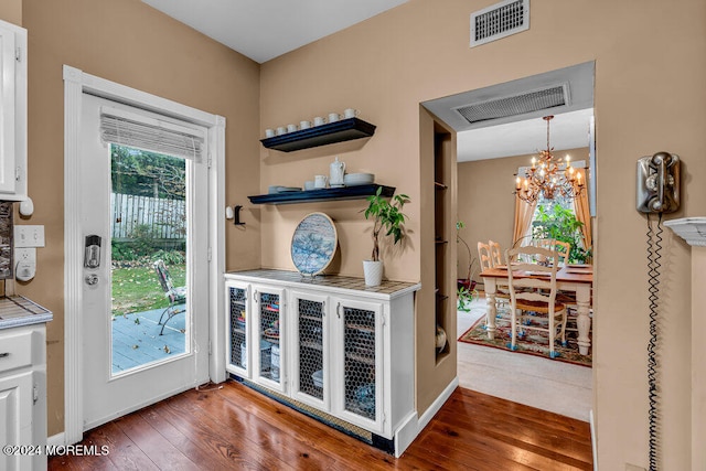 doorway featuring dark hardwood / wood-style flooring and an inviting chandelier