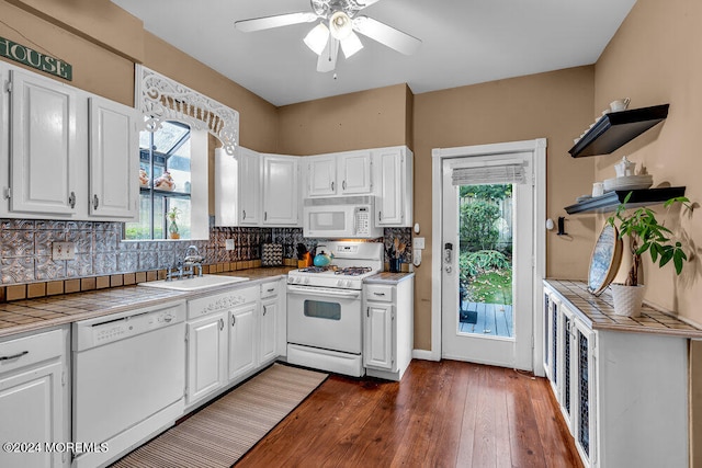 kitchen featuring tile counters, white cabinets, sink, and white appliances