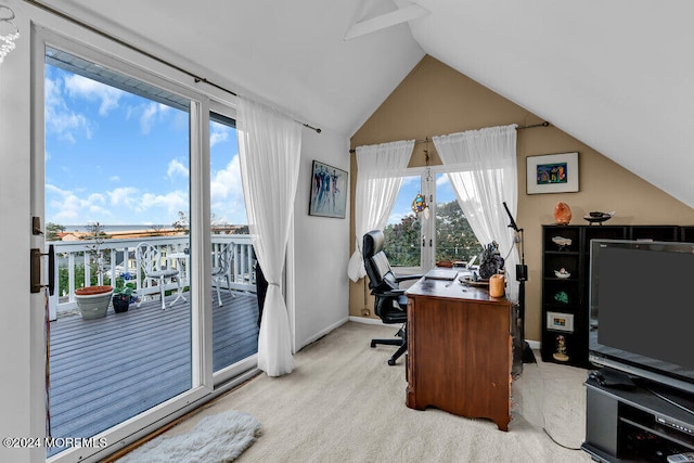 office space with a wealth of natural light, lofted ceiling, and light colored carpet