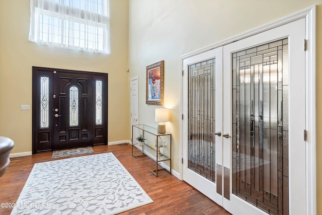 foyer featuring french doors, dark hardwood / wood-style floors, and a high ceiling