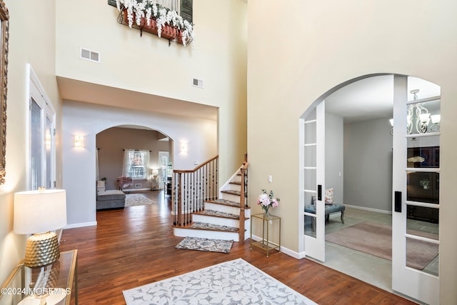 foyer entrance featuring a towering ceiling and dark hardwood / wood-style floors