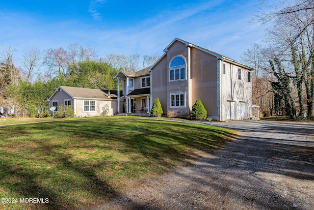 view of property featuring a garage and a front lawn