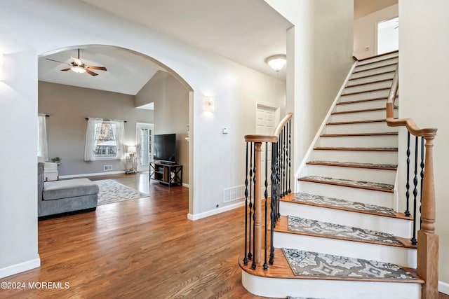 staircase featuring ceiling fan and hardwood / wood-style flooring