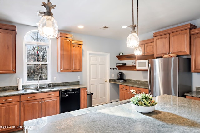 kitchen featuring stainless steel refrigerator, light stone countertops, sink, black dishwasher, and pendant lighting