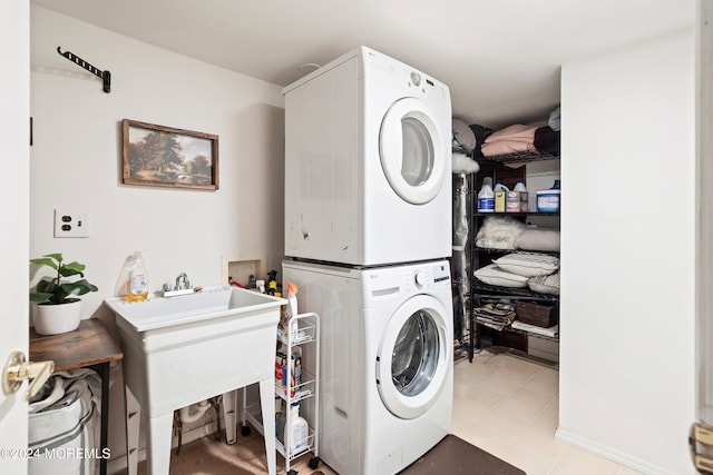 laundry room featuring stacked washer / drying machine, light tile patterned flooring, and sink