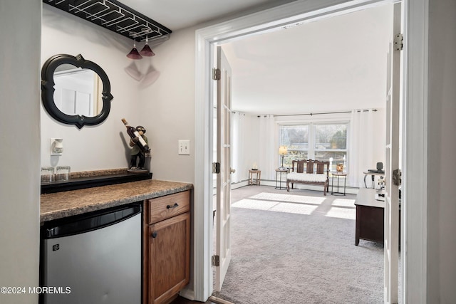 hallway with light carpet and a baseboard heating unit