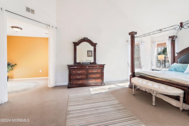 bedroom featuring high vaulted ceiling and light colored carpet