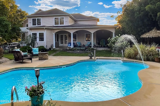 view of swimming pool with french doors and a patio area