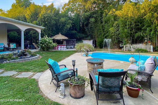 view of swimming pool featuring a yard, a patio, and a fire pit