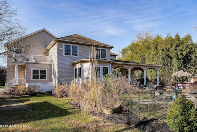 back of house featuring a yard and a balcony