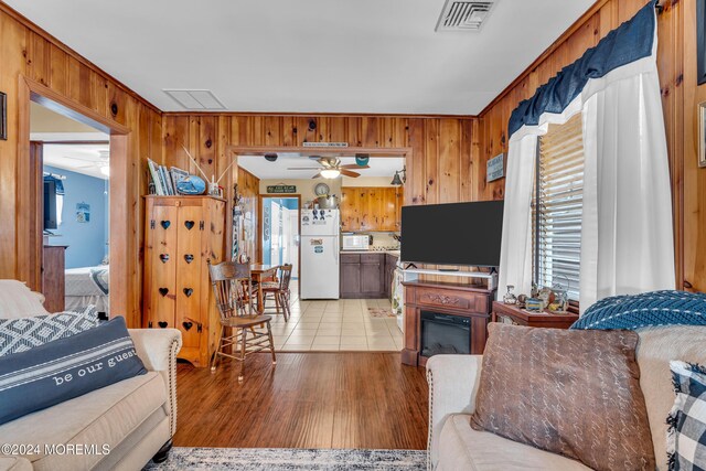 228 Hancock Ave, Seaside Heights, NJ 08751 - living area featuring wood walls, a ceiling fan, light wood finished floors, and a glass covered fireplace