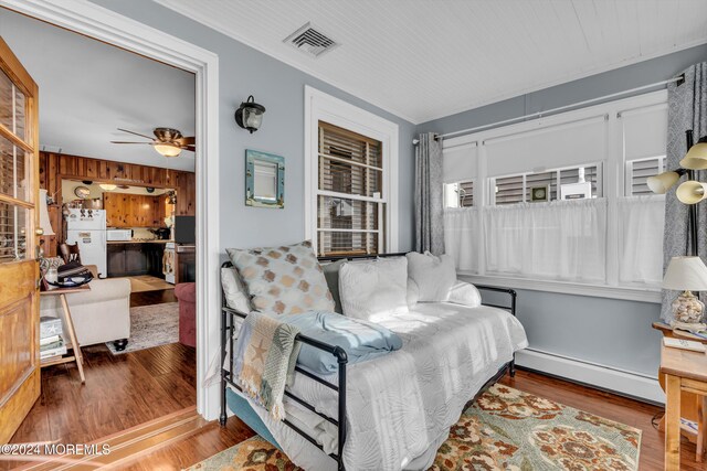 228 Hancock Ave, Seaside Heights, NJ 08751 - living area with a baseboard radiator, ceiling fan, wood finished floors, and wooden walls