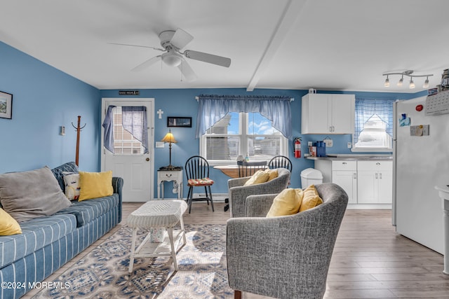 living room featuring beam ceiling, hardwood / wood-style flooring, and ceiling fan