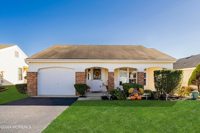 view of front of home with covered porch, a garage, and a front yard