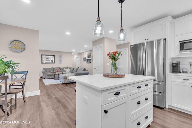 kitchen featuring decorative backsplash, stainless steel appliances, decorative light fixtures, light hardwood / wood-style flooring, and white cabinetry