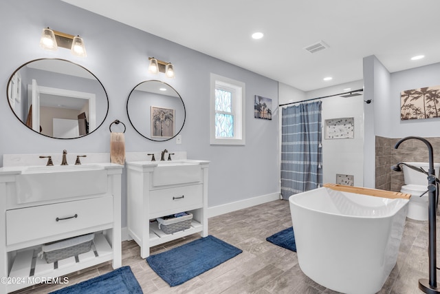 bathroom with hardwood / wood-style floors, vanity, and separate shower and tub