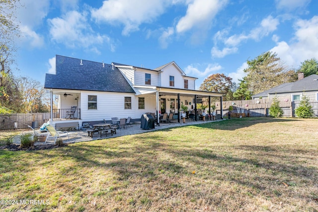 back of house with ceiling fan, a patio area, and a lawn