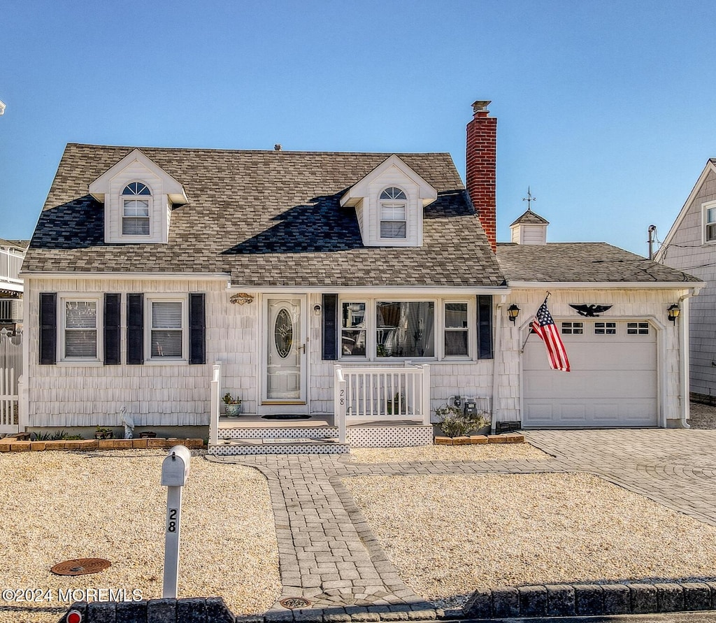 cape cod-style house featuring a garage