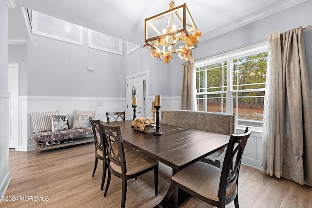 dining room featuring light hardwood / wood-style floors, crown molding, and a chandelier