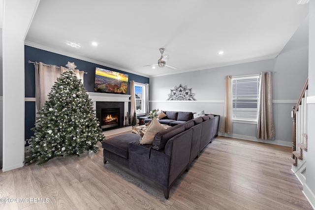 living room with wood-type flooring, ceiling fan, and ornamental molding