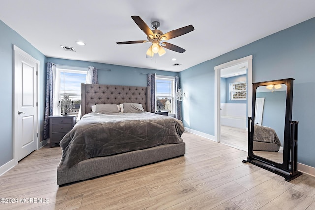 bedroom with ensuite bath, light hardwood / wood-style flooring, and ceiling fan