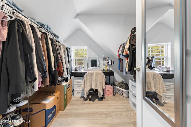 walk in closet with light hardwood / wood-style floors and lofted ceiling