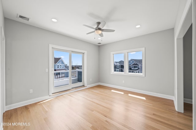 unfurnished bedroom with access to outside, multiple windows, ceiling fan, and light hardwood / wood-style flooring