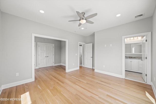 unfurnished bedroom with a closet, light hardwood / wood-style floors, ceiling fan, and ensuite bathroom