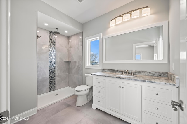 bathroom with tile patterned flooring, toilet, vanity, and tiled shower