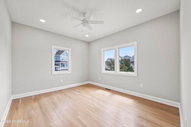 spare room with light hardwood / wood-style flooring, a wealth of natural light, and ceiling fan