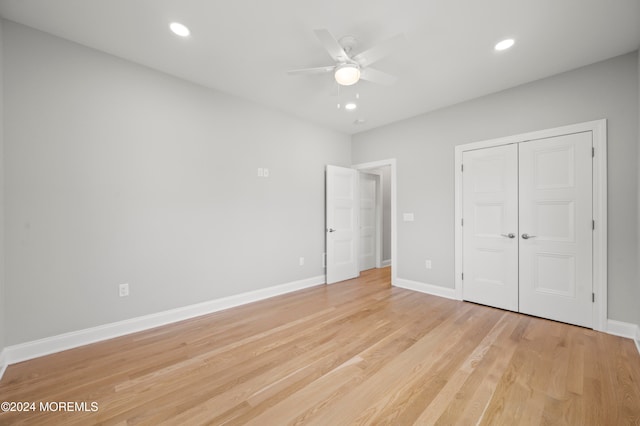 unfurnished bedroom featuring a closet, light hardwood / wood-style flooring, and ceiling fan