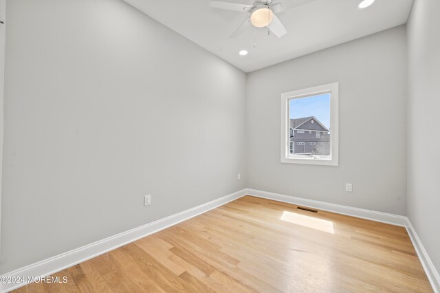 empty room with hardwood / wood-style flooring and ceiling fan