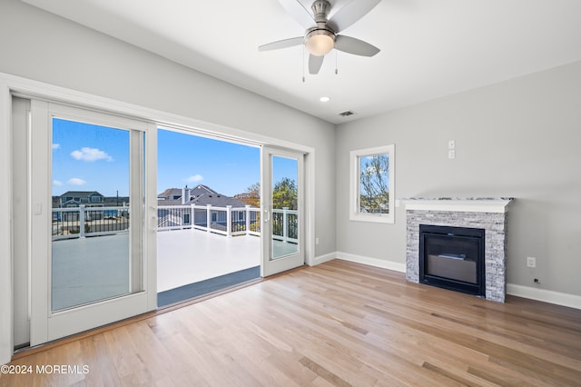 unfurnished living room featuring a fireplace, light wood-type flooring, and ceiling fan