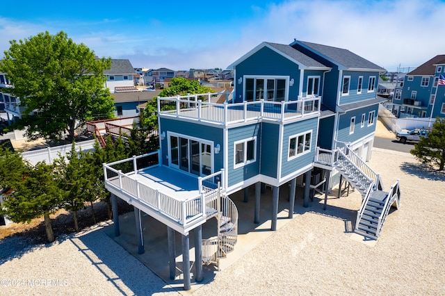 rear view of property featuring a balcony and a carport