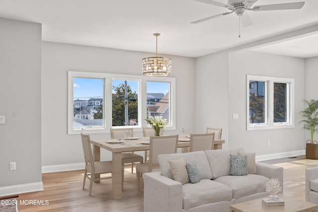 living room featuring light hardwood / wood-style flooring and ceiling fan with notable chandelier